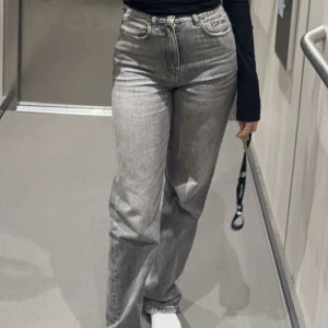 Grå jeansbyxor - Snygga grå jeansbyxor med hög midja och straight passform. Perfekta för en avslappnad stil. De har klassisk femficksdesign och knappgylf.