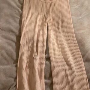 Rosa  ribbade byxor - Säljer ett par snygga rosa ribbade byxor med loose passform. Byxorna har en hög midja och är perfekta för en avslappnad stil. De är tillverkade i ett mjukt och bekvämt material som ger en skön känsla hela dagen.