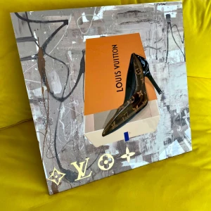 Tavla Svarta pumps från Louis Vuitton - Eleganta svarta pumps från Louis Vuitton med hög klack och spetsig tå. Skorna har det ikoniska monogrammönstret i guld och kommer i originalförpackning.