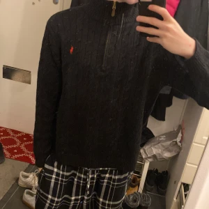 Svart stickad tröja från Polo Ralph Lauren - Riktigt fet quarterzip från polo ralph lauren. Mycket bra skick och kvalite. Använts bra ett fåtal gånger men ändå riktigt bra!