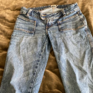 Blå jeans från 157 Paris - Snygga blå jeans från 157 Paris med klassisk femficksdesign. De har en rak passform och är perfekta för en avslappnad stil. Jeansen har en knappgylf och bälteshällor för extra stil och funktion.