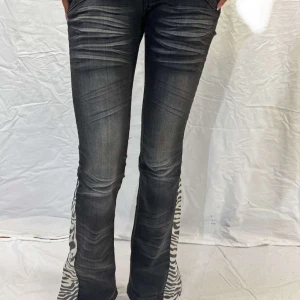 Svarta bootcut jeans med zebramönster - Snygga svarta bootcut jeans med coolt zebramönster på utsidan av benen. Säljer då dom inte satt så bra, men dom är verkligen SKITSNYGGA! (inte mina bilder💕)