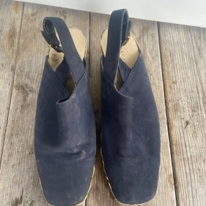 Mörkblå mocka sandaler med flätad sula - Snygga mörkblå sandaler i mocka med en unik flätad sula. De har en öppen häl och remmar för enkel passform. Perfekta för en stilren look.