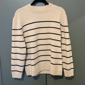 Beige randig kashmir tröja från Zara - Säljer en stilren beige tröja från Zara med ränder. Tröjan har en rund halsringning och långa ärmar, perfekt för en avslappnad look. Aldrig använd. 
