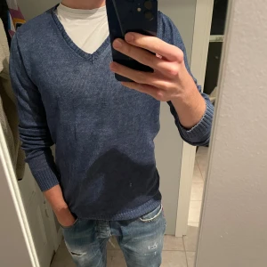 Blå V-neck Stenströms - Snygg blå V-ringad tröja från Stenströms i 100% linne. Perfekt för en stilren look med ribbade muddar och långärmad design. Passar bra till jeans för en avslappnad stil.