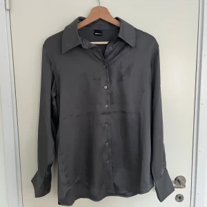 Grå skjorta - Stilren grå skjorta från Gina Tricot. Passar till fest som vardag✨ Skjortan har lite fläckar fram vid bröstet