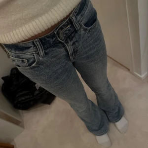 Blå bootcut jeans - Snygga blå bootcut jeans med klassisk femficksdesign och knappgylf. Perfekta för en avslappnad stil. Använda få gånger och i jättebra skick, pris kan diskuteras