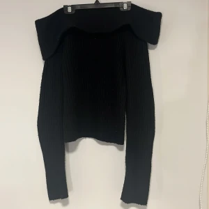 Svart stickad offshoulder tröja  - Snygg svart offshoulder tröja från H&M. Det är en ribbad offshoulder tröja som man själv kan välja hur mycket man vill vika ner den vid halsen och axlarna själv. Passar perfekt nu när det är lite kallare ute! Säljer på grund av att den inte används så mycket längre även om den är väldigt fin. Tröjan är i storlek XS men skulle säkert passa som S också utan problem. Köpte för 249kr. Den är nopprig här och var men annars i bra skick utan några övriga defekter! Pris KANSKE kan ändras. Hör av er då!🫶🏻