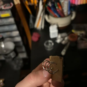 Silverfärgade örhängen - Säljer ett par stilrena silverfärgade örhängen i form av små ringar. Perfekta för en minimalistisk look och passar till alla tillfällen.