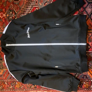 Svart tracksuit från Palm Angels - Snygg tracksuit från Palm Angels. Jackan och byxorna säljs tillsammans eller separat. 1250 styck eller 2000 tillsammans. Skriv för fler bilder eller frågor.