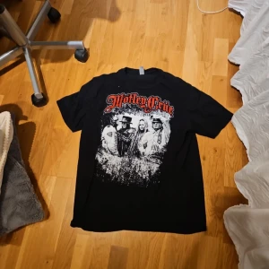 Svart Mötley Crüe t-shirt - Cool svart t-shirt med Mötley Crüe-tryck i rött och vitt. Perfekt för rockälskare som vill visa sin stil. T-shirten har korta ärmar och en normal passform.