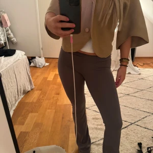 Yoga pants Nelly grå, XS - Snygga bruna byxor med tight passform. Perfekta för en stilren look och kan enkelt matchas med olika toppar. Byxorna har en enkel design utan mönster eller extra detaljer.
