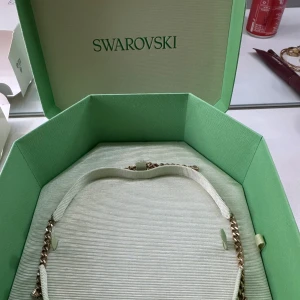 Swarovski halsband (dextra, guld)  - Säljer mitt halsband då den inte kommer till någon användning längre, guld pläterad. Lite smutsig men kan tvättas såklart. Allt till följer, (box, påse, snöre, kartong,intygspapper). Nypris:3000kr. Pris går att diskutera! 