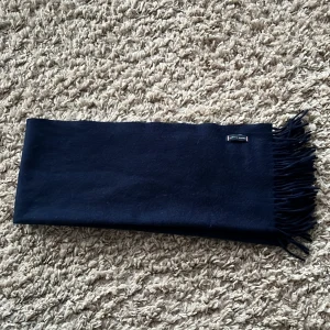 100% Kashmir halsduk  - Mörkblå halsduk gjord av 100% Kashmir ifrån Tommy hilfiger, använd max 5 gånger.  Kommer knappt till användning så väljer att sälja vidare! 