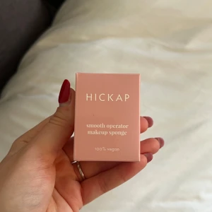 HICKAP Smooth Operator Makeup Sponge - Säljer en HICKAP Smooth Operator makeupsvamp. Den är 100% vegansk och kommer i en snygg rosa förpackning. Perfekt för att applicera foundation och andra flytande sminkprodukter för en jämn och fin finish.