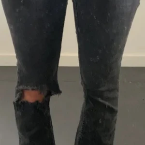 Svarta lågmidjade jeans med hål - Snygga svarta jeans med en cool slitning på ena benet.  Rätt så onanvänd, köpt från USA för 3 år sen💓priset går och diskuteras