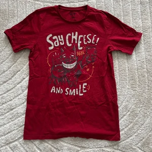 Röd t-shirt med tryck - Graphic röd t-shirt med ett humoristiskt tryck .Perfekt för en avslappnad stil med korta ärmar och rund hals. 