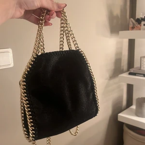 Stella macartney liknande väska  - Säljer min Stella macartney liknande väska med guldkedja. Väskan har en mjuk finish och stängs med en tryckknapp. Endast använd någon enstaka gång. Om du har frågor eller önskar mer bilder är det bara att höra av sig!💓