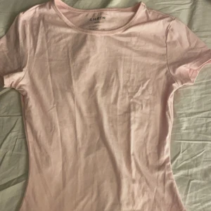 Ljusrosa t-shirt från Shein - Säljer en ljusrosa t-shirt från Shein. Den är kortärmad och har en enkel design som passar perfekt till vardags. Materialet är mjukt och bekvämt.