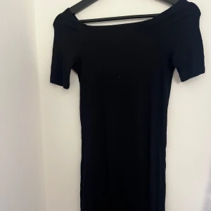 Svart offshoulder klänning från Bik Bok - Snygg svart offshoulder klänning från Bik Bok i ribbat material. Knappt använd har inga defekter. 