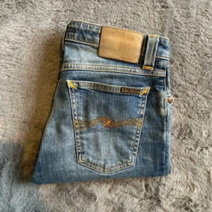 Nudie jeans 27/32 - Säljer ett par nudie jeans som är använda men  är som nya! Jeansen storlek W27 L32 och modellen heter skinny lin! Skriv för fler bilder eller för frågor/ funderingar!   A ≈ 81 cm B ≈ 37 cm C ≈ 43 cm D ≈ 22 cm E ≈ 15 cm F ≈ 22 cm Längd ≈ 102 cm