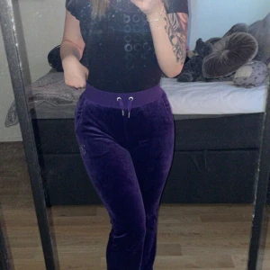 Juicy Couture byxor - Säljer ett par lila mjukisbyxor från Juicy Couture i storlek XXS. Byxorna har en glittrig Juicy-logga på baksidan och snörning i midjan. Dem är jätte sköna, säljer då dem bara tar plats i garderoben🤍Inga defekter alls, nästan aldrig använda. Ligger ute på fler sidor
