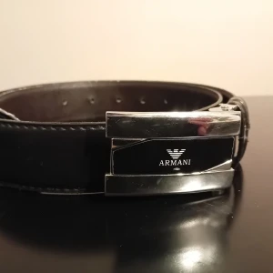 SVART ARMANI BÄLTE - Hej!, säljer ett svart ARMANI bälte som är i väldigt bra skick och är i st.100-barn. Lite färg har försvunnit under ARMANI logan, syns på bild 1.