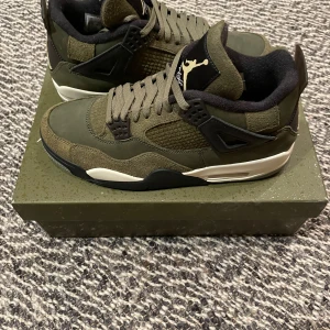 Air Jordan 4 Retro SE Craft - Snygga Air Jordan 4 Retro SE Craft sneakers i en stilren olivgrön färg. Skorna har en klassisk design med snörning och en bekväm sula. Perfekta för dig som vill ha både stil och komfort.