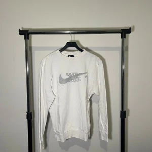 Nike sweatshirt - Säljer en stilren vit långärmad tröja från Nike med ett stort grått logotryck på framsidan. Perfekt för en avslappnad look. Tröjan är i storlek XS och har en klassisk passform.