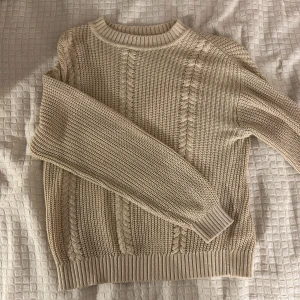 Beige stickad tröja - Säljer en mysig beige stickad tröja med kabelstickat mönster. Lappen har klippts av men tröjan passar 134-140 i barnstorlek 🫶💕