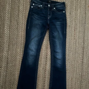 Snygga True Religion jeans!  - Det är i nytt skick, endast använda ett fåtal gånger! Säljer då det sitter lite tajt på mig💞Jättefina rosa detaljer på fickorna där bak och fram. Nypris är 1299 kr. Storlek 25 som jag skulle säga motsvarar xs-s. Skriv för mer frågor eller bilder💞