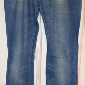 Blå jeans från The Emmett Company - Snygga blå jeans från The Emmett Company med klassisk design. De har en rak passform och är perfekta för en avslappnad stil. Märket 'BILL' syns på insidan. Perfekta för dig som gillar en tidlös look. Storlek 32/32