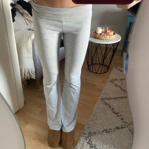Grå mjukisbyxor - Säljer ett par grå mjukisbyxor med låg midja och bootcut-stil. Byxorna är perfekta för en avslappnad look och är gjorda i ett mjukt material som ger en bekväm passform. Passar mig som är 177 cm lång!