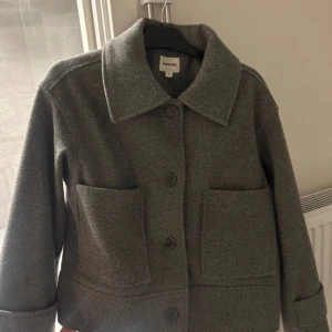 Grå kappa - Snygg grå kappa från Kappahl med stora fickor och knappar framtill. Jackan har en klassisk krage och är perfekt för kyligare dagar. Nypris 900.  Inga defekter eller nopprig alls!!!💗