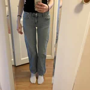 Blå jeans från 157 - Snygga blå jeans från 157 med en klassisk straight fit. De är lågmidjade och har en enkel design med fem fickor och knappgylf. Perfekta för en avslappnad stil.