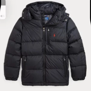 Polo jacka  - Snygg svart dunjacka från Ralph Lauren med huva och dragkedja. Jackan har långa ärmar och två praktiska fickor med dragkedja. Perfekt för kyliga dagar. Pris kan diskuteras!!!