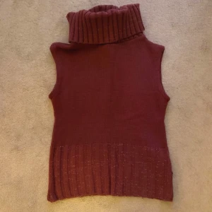 Vinröd ärmlös polotröja - Snygg vinröd ärmlös polotröja med ribbad krage och nederkant. 