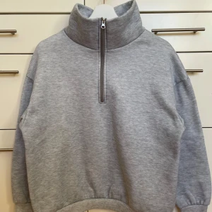 Grå sweatshirt med dragkedja från Shein - Säljer en mysig grå sweatshirt med hög krage och dragkedja. Tröjan har långa ärmar och ribbade muddar vid ärmslut och nederkant. Perfekt skick!