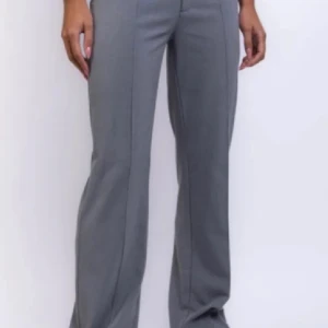 Grå kostymbyxor från Madlady - Snygga grå kostymbyxor från Madlady i en klassisk straight fit. Perfekta för en stilren look. Byxorna har en hög midja och är tillverkade i ett bekvämt material som ger en elegant känsla.