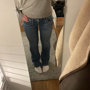 Blå jeans med låg midja - Snygga blå jeans med låg midja och bootcut passform. storlek 27/30, nypris runt 600, men en liten defekt på sista bilden därav priset! Köpare står för frakten