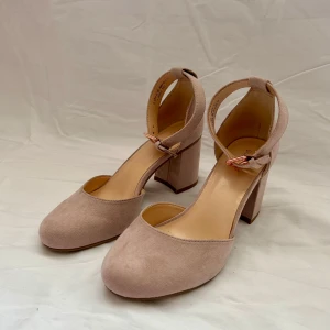 Beige pumps från Graceland - Eleganta beige pumps från Graceland med en bekväm blockklack och justerbart spänne runt ankeln. Perfekta för en stilren look.