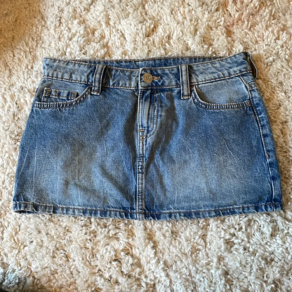 Säljer en superfin jeanskjol i blå denim som jag har köpt här på Plick och säljer den för att den var tyvärr för liten för mig. Den är kort och har en klassisk femficksdesign med knappar och bälteshällor. . Kjolar.