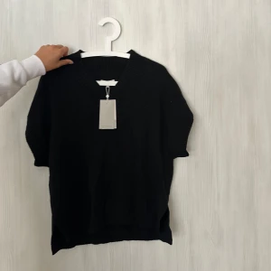 Svart tröja - Det är som en väst som du kan ha själv eller över exempelvis en vit skjorta. Helt oanvänd som ni ser då taggen är kvar. 