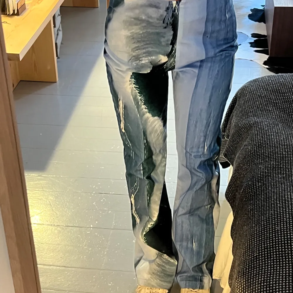 Ett par bootcut byxor med grafiskt tryck, hög midja, dragkedja fram. Jeans & Byxor.