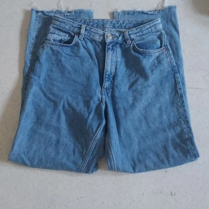 Blå jeansshorts från Monki - Säljer ett par snygga blå jeans från Monki. De är högmidjade med en perfekt passform, vilket ger en cool och avslappnad stil. Jeansenhar klassiska fyra fickor och en knappgylf. Perfekta för skolan💙