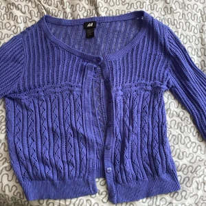 Lila stickad kofta - NY, jag har haft den länge men tagit på mig den 1 gång den 13 juli 2022. Aldrig vart smutsig, du kan köpa den till ett barn men även om du har storlek XXS-XS funkar den, på S kan de bli lite kortare och tajtare.+ man ser igenom. 