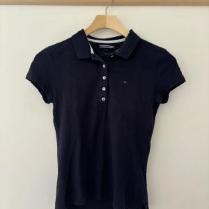 Piké  - Marinblå pikétröja från Tommy Hilfiger. Använd tre gånger men sen har den bara legat i min garderob och nu är den för liten.