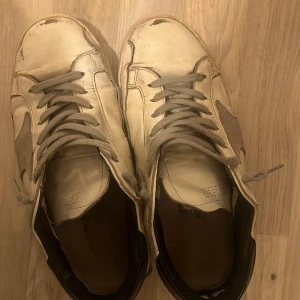 Golden goose - Väldigt beat up Golden goose skor| hål vid hälen vid bägge dojor| sulan har lossnat vid båda sulorna| alla dessa defekter e möjliga att fixa via skomakare.