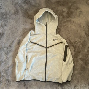 Nike full zip  - Grå Nike zip jag fick i inbyte, x antal defekter därav priset, men helheten är bra, vid intresse så kan jag visa alla defekter.  M men sitter som S