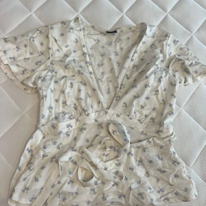 Topp - En vit topp med blommor från Gina! Den har som två ”snören” (se bild) som man kan välja att knyta antingen framifrån eller bakifrån. Supersöt!🫶🏼